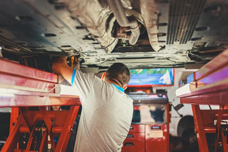 Un mécanicien travaille sous une voiture dans son garage