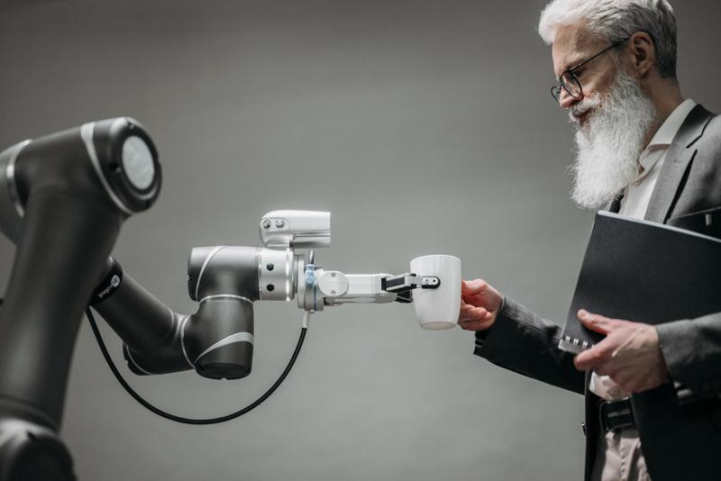 Un bras robotisé tend une tasse de café à un homme